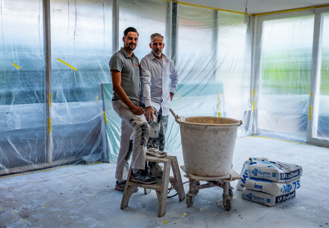 Stukadoors met gereedschap in een kamer